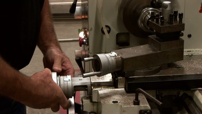 A skilled worker operating a metal lathe.