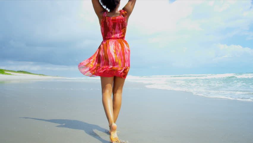 Pretty girl in summer dress reveling being alone in ocean on beach vacation shot on RED EPIC