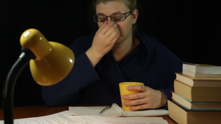 Tired overworked woman in bathrobe working overtime in home office at night