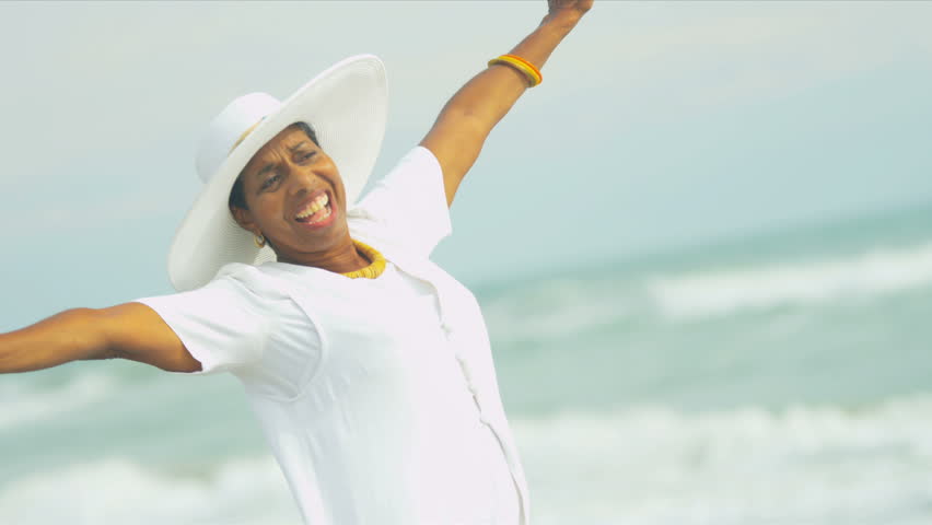 Beautiful elegant ethnic senior female reveling in her lifestyle beside a tropical ocean shot on RED EPIC