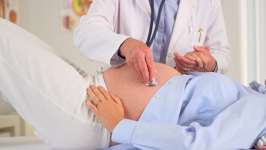 Doctor listening to a pregnant woman's stomach