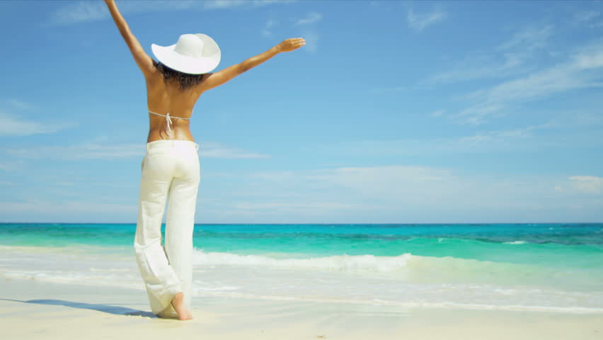 Beautiful Latin American female celebrating her lifestyle beside a tropical ocean shot on RED EPIC