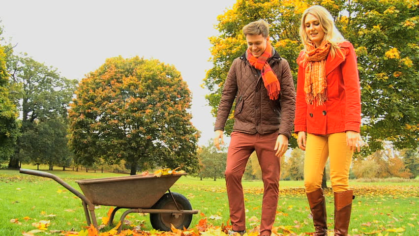 Caucasian fun loving couple playing in the park on cold autumn day