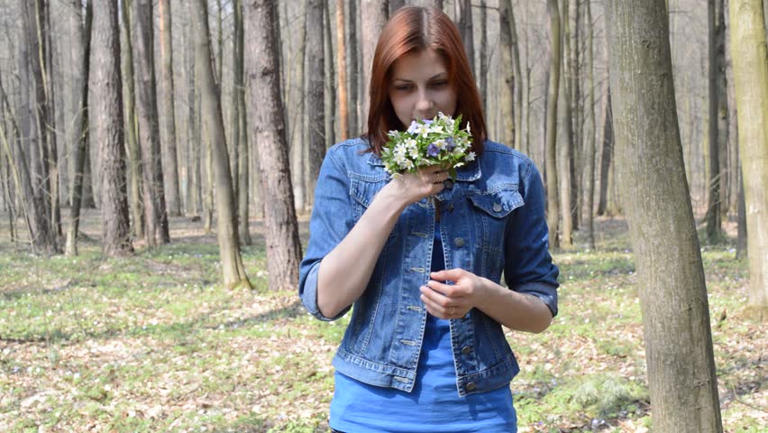 smiling girl smelling wildflowers and sneezes