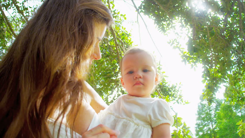 Caucasian loving mother holding little baby in garden