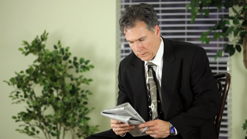 A mature man going through with a newspaper's employment want ads. (Shot with Canon MKII for shallow DOF)