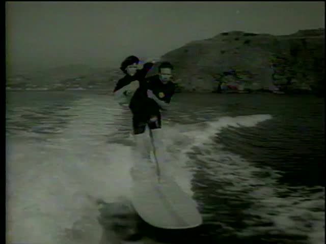 Boatsurfer pick up his partner on his shoulders, they fall down, swim towards the boat San Francisco circa 1964-MGM PICTURES, UNIVERSAL-INTERNATIONAL NEWSREEL, USA, filmed in 1964