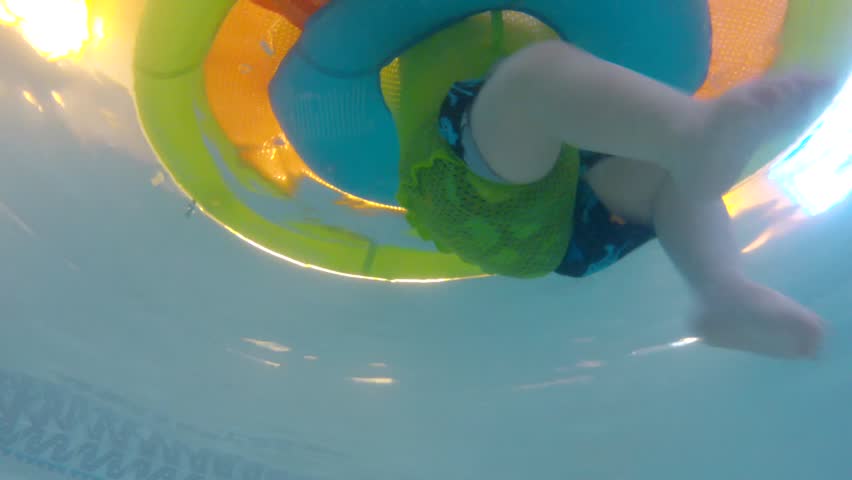 Underwater shot of a cute little baby boy at the swimming pool with his family.