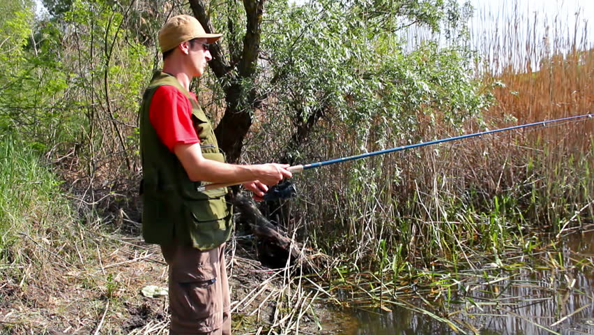 sport fisherman fishing on a river bank with fishing rod,video clip ; Sport fishing 