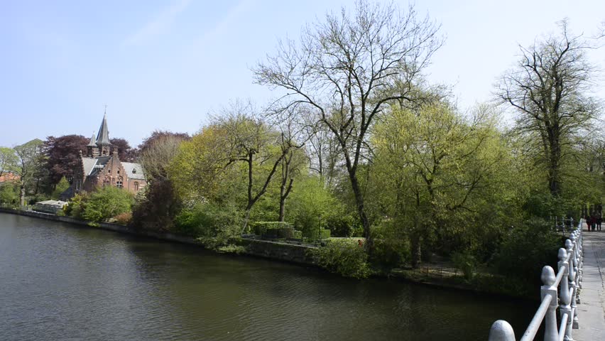 Minnewater lake (Lake of Love) in Bruges, Belgium: panoramic view of the lake from the bridge. Slow camera pan.