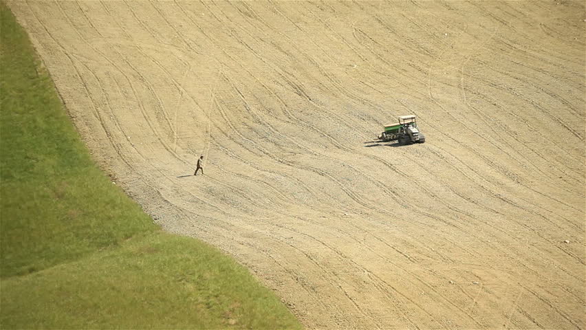 Farmer going at work in field and plowing land driving tractor