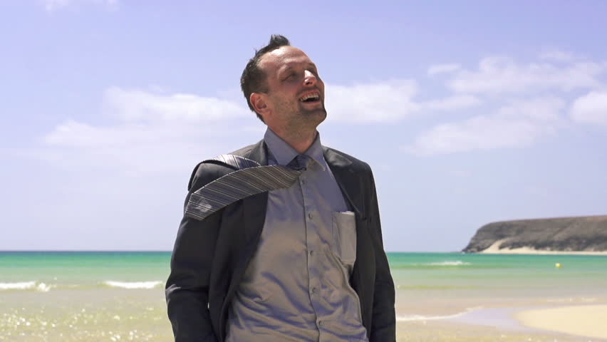 Happy young businessman on beautiful exotic beach
