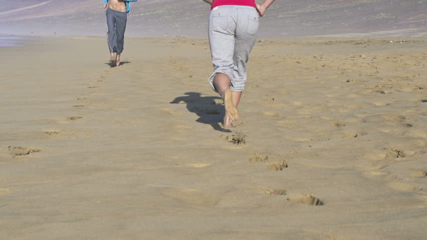 Man and woman jogging on the beach
