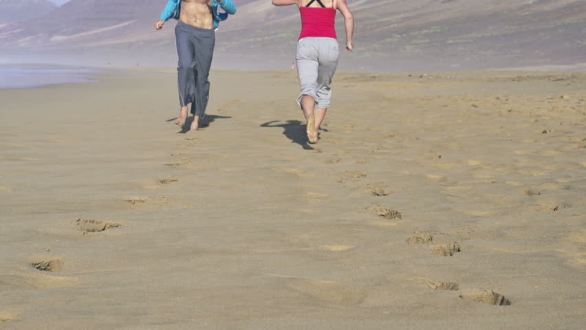 Man and woman jogging on the beach, super slow motion, shot at 240fps

