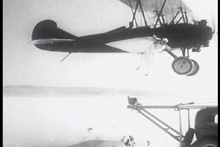 1930s - Great black and white stunt footage of a man jumping off a plane's wing onto the top of a moving car.