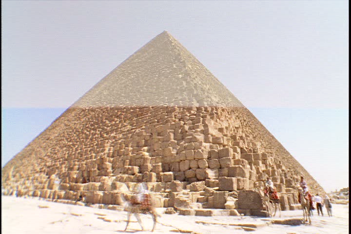 Scenic shots of the Great Pyramids; WS of pyramid with a few men on camels nearby.