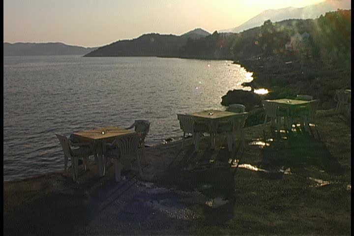 An empty outdoor restaurant next to the water 