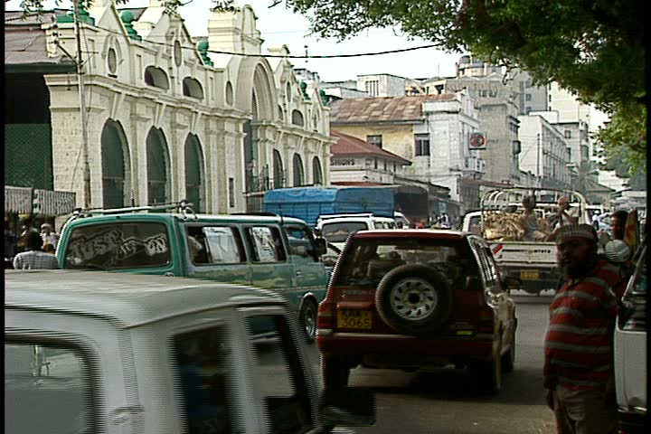 MOMBASA, KENYA, AFRICA - DECEMBER 01, 1998: WS Mombasa street clogged with heavy traffic. Automobiles and trucks pass camera.