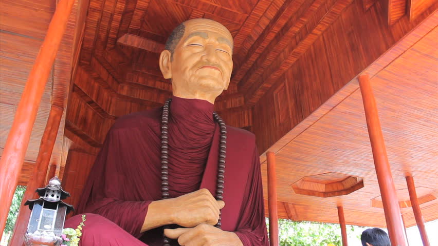 BANGKOK, THAILAND, 2103: A man can be seen paying respects to a huge oversized Buddhist monk statue in Bangkok, Thailand.