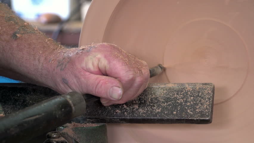 Dargaville, New Zealand. May 2013. Close up of wood carver using his chisel creating a timber bowl from the wood of a swamp kauri tree.