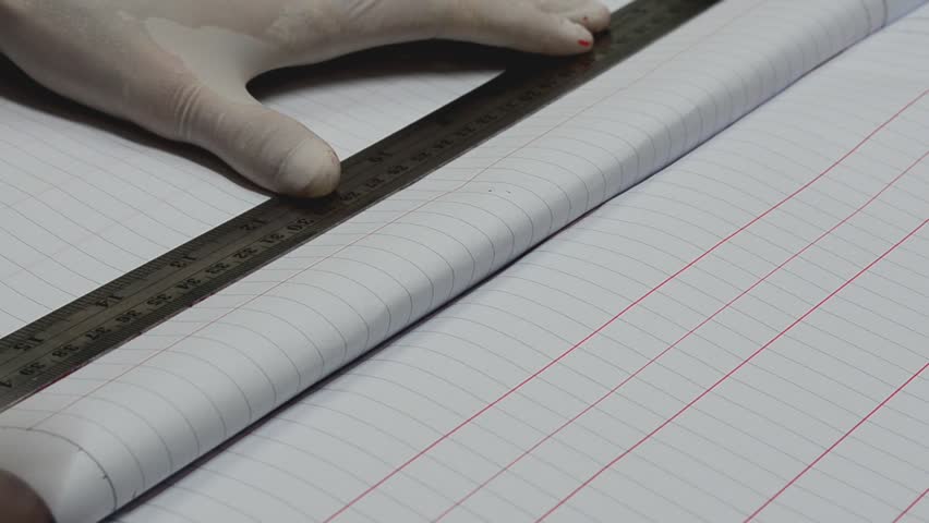 Close up drawing the red line onto a notebook