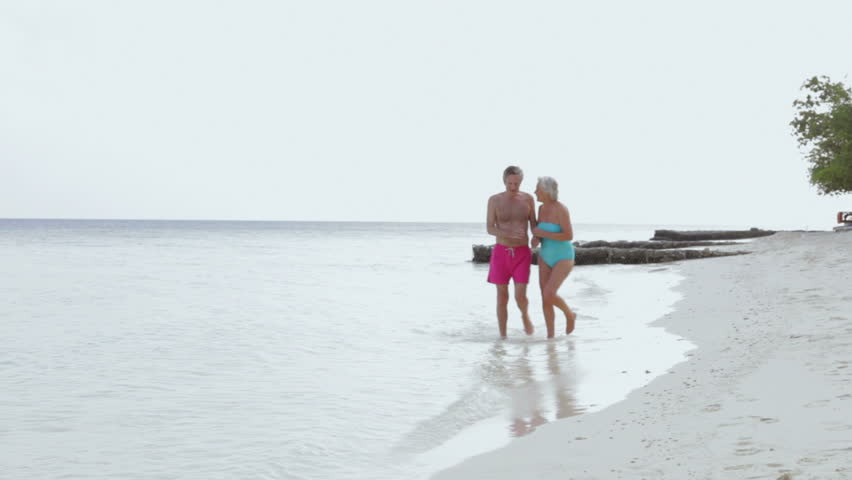 Senior Couple Walking On Beautiful Beach
