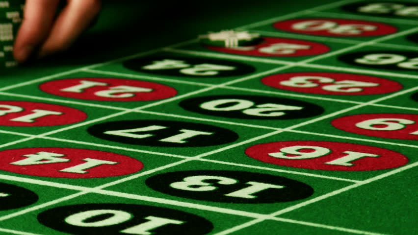 Chips pushed in on a roulette table in slow motion