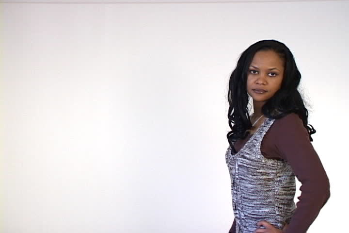 A young African American woman crosses her arms and gives some attitude.