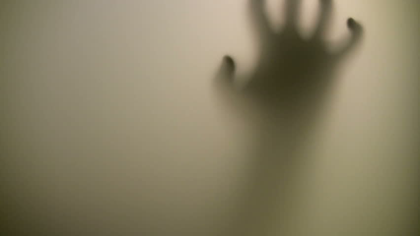 Victim. Terrified hand behind glass