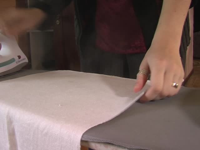 Woman ironing pieces of material