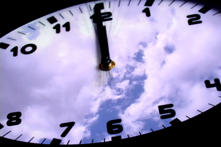 Background of cloudscape reflected on face of circular clock with black background