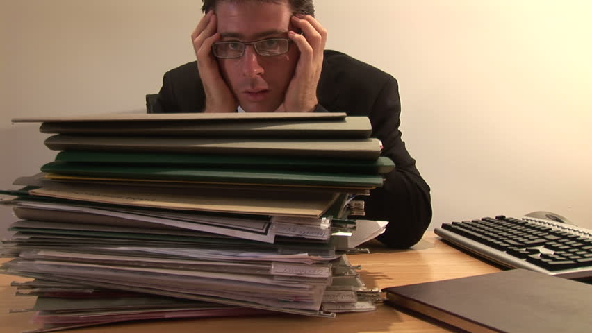 Businessman Staring at Pile of Paperwork