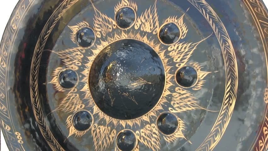 A monk bangs a giant gong twice at a temple in Bangkok, Thailand.