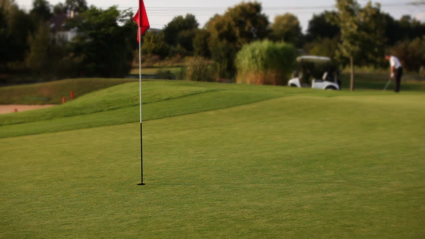 Golf player teeing off on beautiful golf course