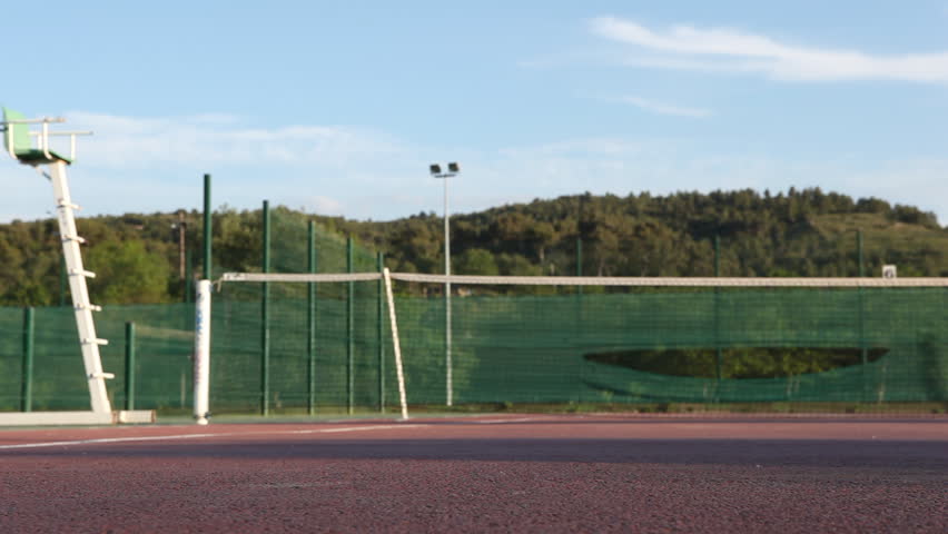 Tennis balls rolling on a tennis court