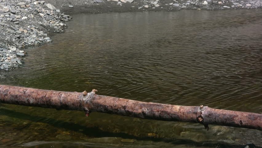 Man balancing across a log over a river. HD 1080i