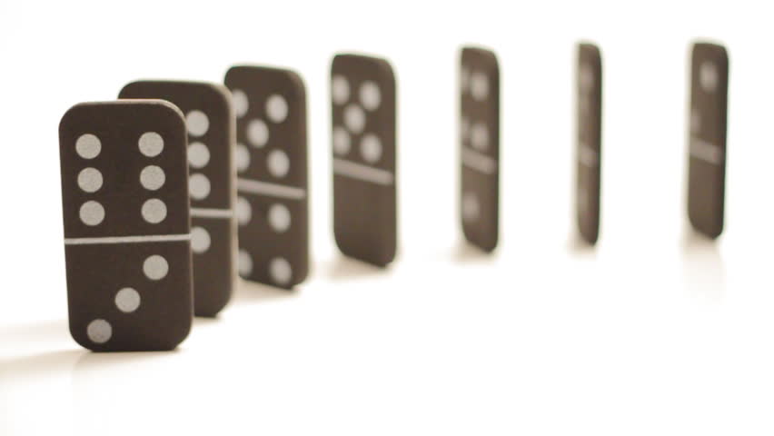 A bunch of light foam dominoes arranged in a row, which are then set to fall, cascading into each other, isolated on white.