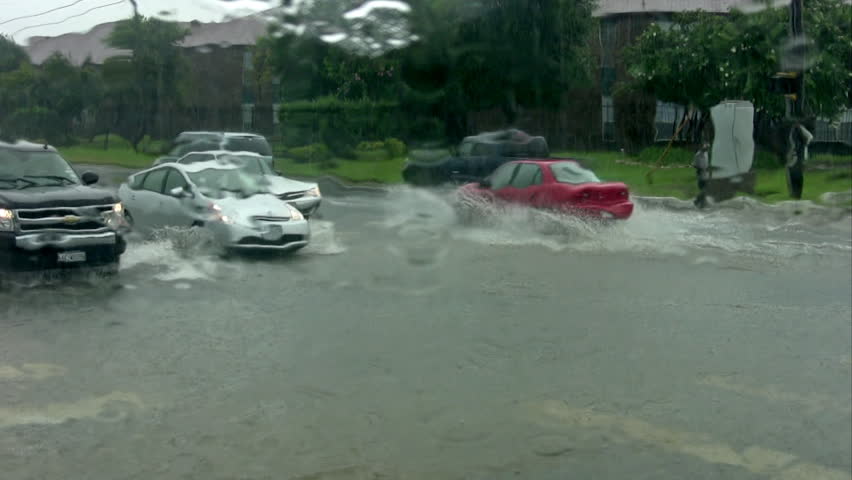 Video of flooded road intersection in San Antonio Texas. Massive rains causing many accidents. Driving through deep water with windshield wipers working. Cars and trucks passing. Residential area. 