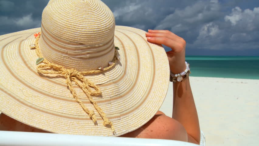 Elegant young female relaxing on white sandy beach looking at aquamarine waters 60 FPS