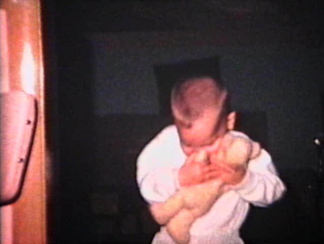 A cute little boy hugs and kisses his teddy bear.