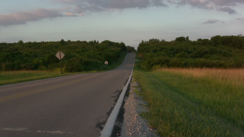 Man Walking down Road Hitch Hiking