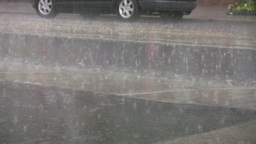 Heavy rain on the street. Summer thunderstorm with hard rain falling on a city street. 
