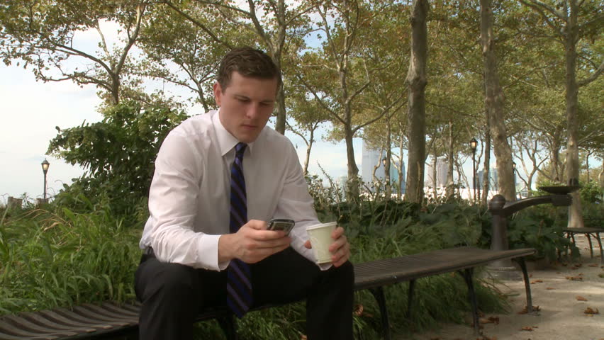 Businessman sits on bench talking on phone (3 of 3)