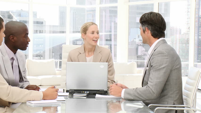 Smiling business people working at a computer in a meeting