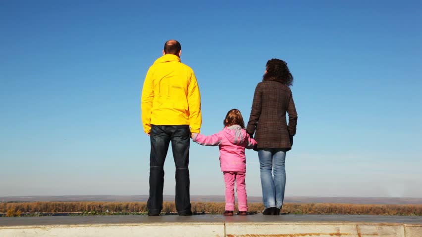 family of mum, daddies and daughter goes upwards from platform before survey kind of wood and sky 
