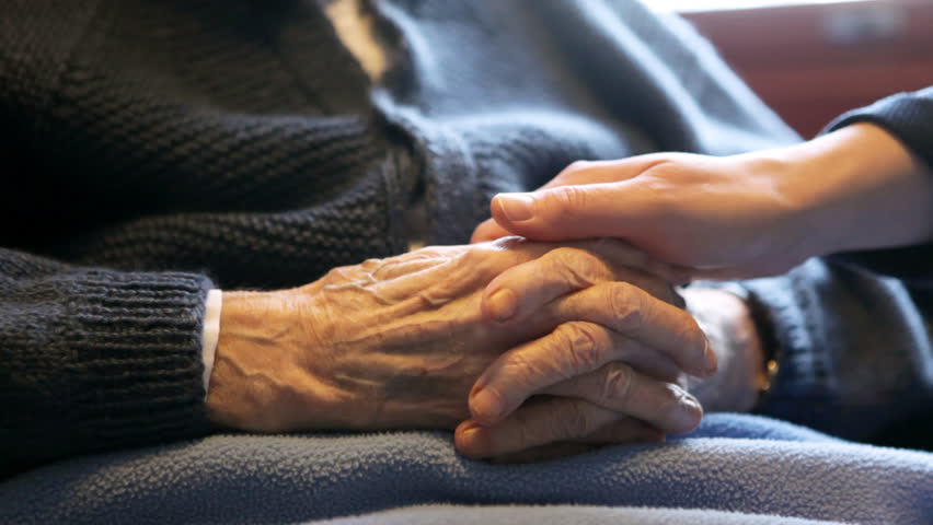 A young hand comforting a old pair of hands.
