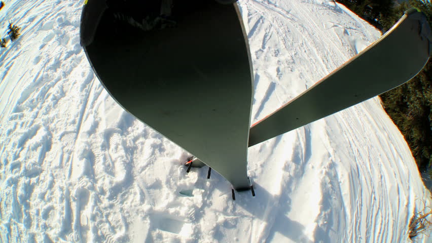 Overhead view of crossed carver downhill skis standing in fresh clean snow high in scenic mountain landscape