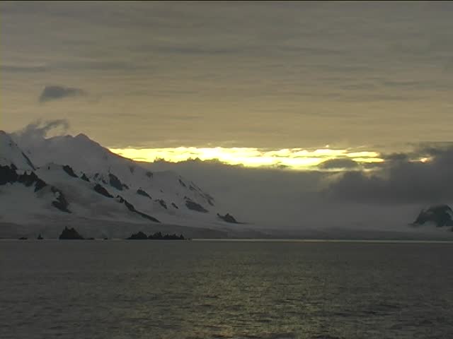 Beautiful snow capped mountains at Antarctica. Taken from a passenger cruise ship at sunset.