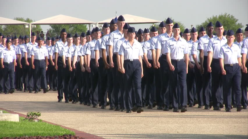 Video of USAF enlisted Basic Training graduates marching in pass in review ceremony. Blue uniform with Drill Sergeants. Lackland AFB San Antonio, Texas. 