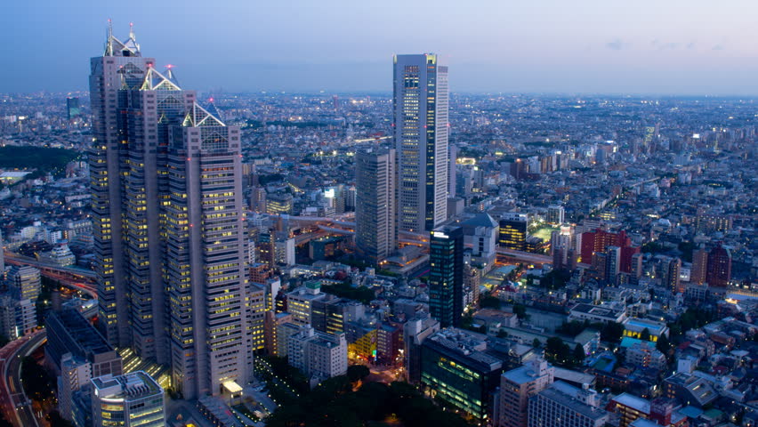 Skyscrapers dominate frame, and lights grow bright as night falls, time-lapse